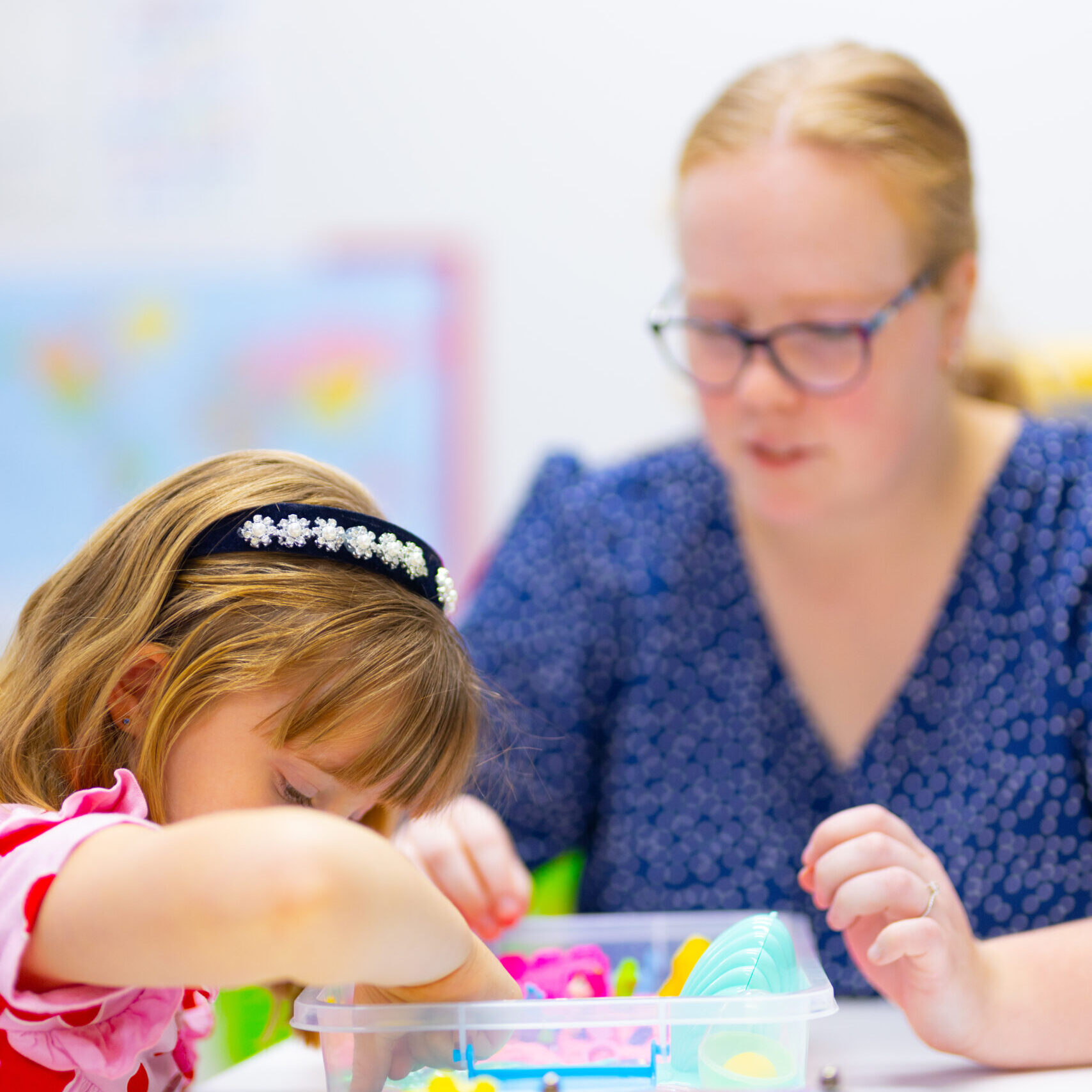 Occupational Therapist assists young girl with fine motor development.